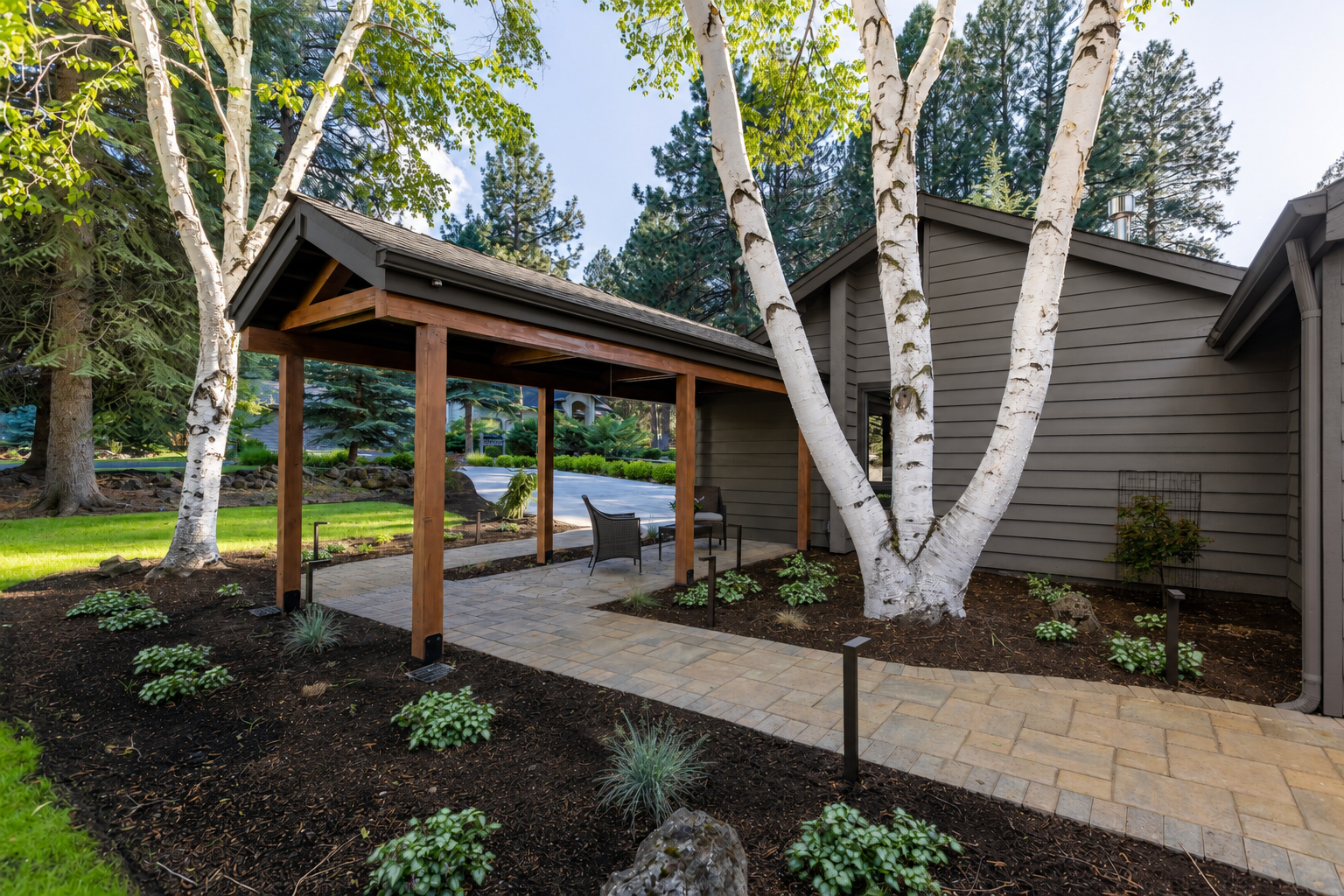 Mountain High entry after — gabled cedar pavilion with paver path and fresh planting beds