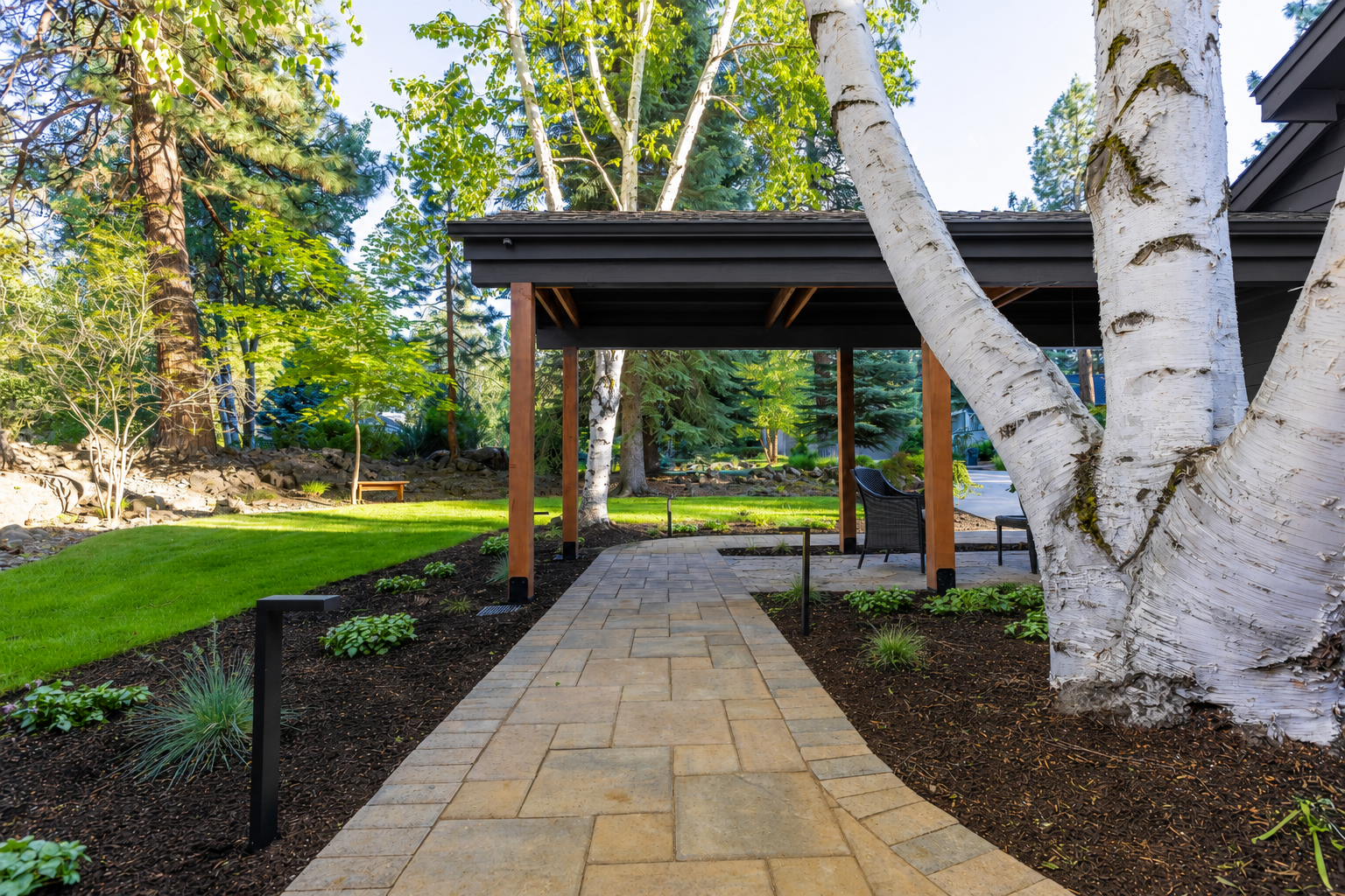 Mountain High — gabled pavilion from lawn showing full structure and lava boulders