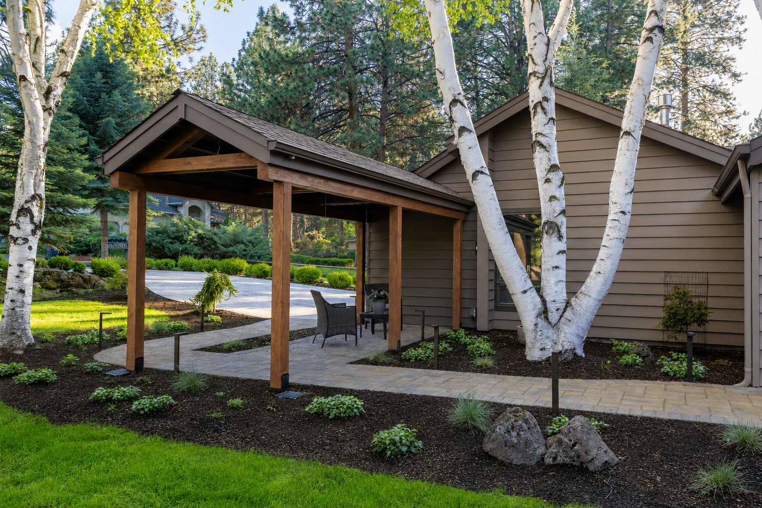 Mountain High — side angle showing pavilion, paver path, lava boulders, and birch trees