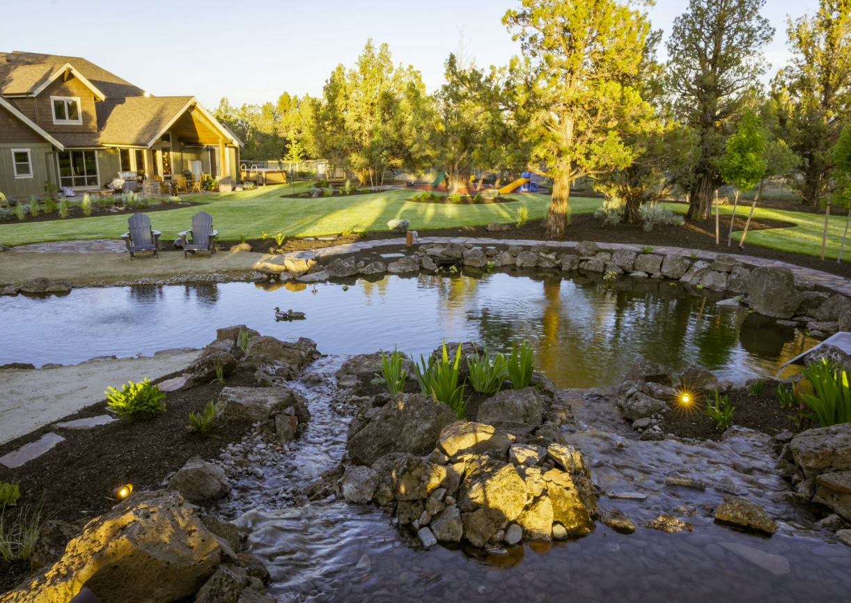 East Bend — finished pond at golden hour with Adirondack chairs