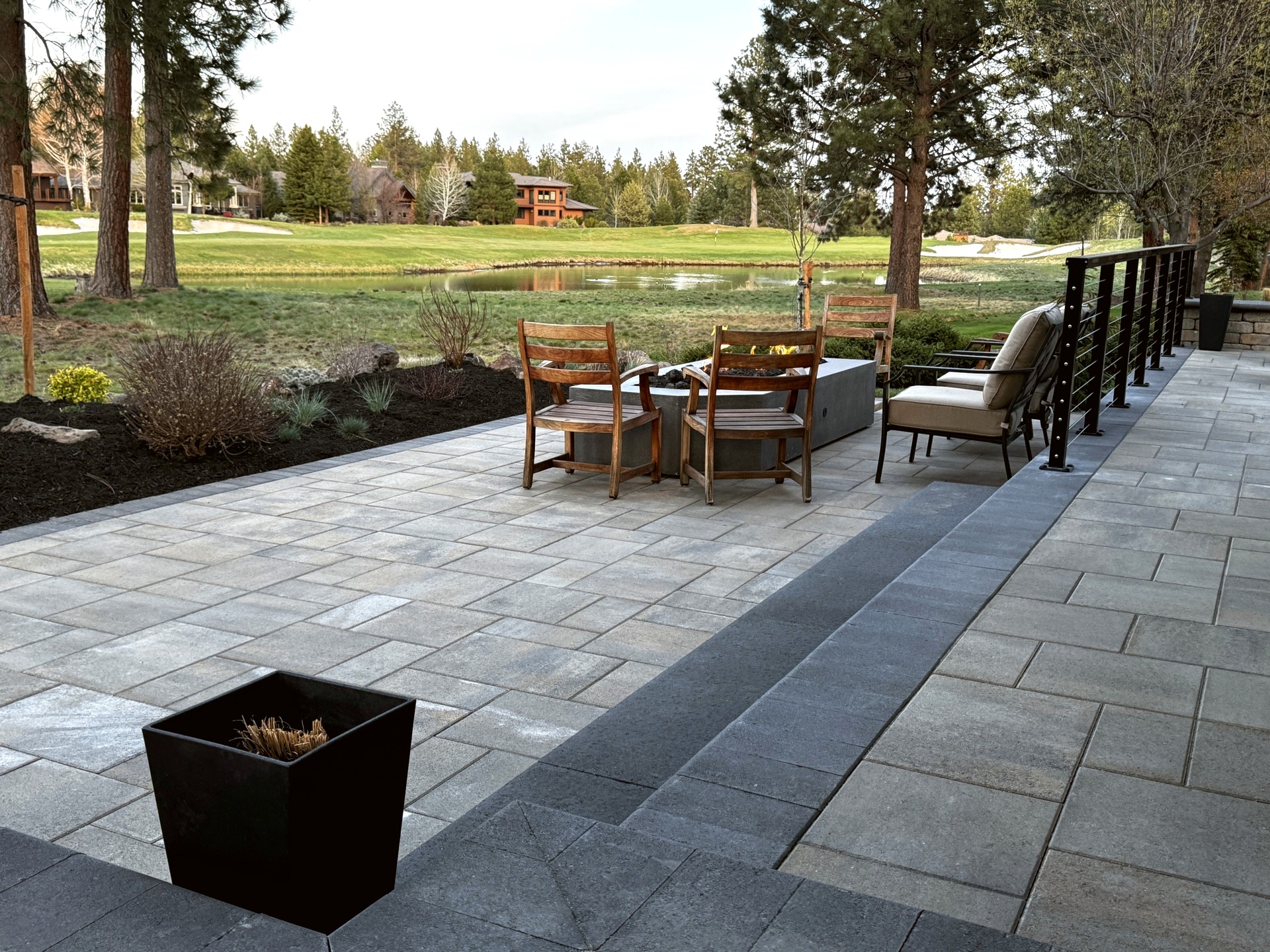 Wide Belgard paver patio with fire table and golf course views in Broken Top Bend Oregon