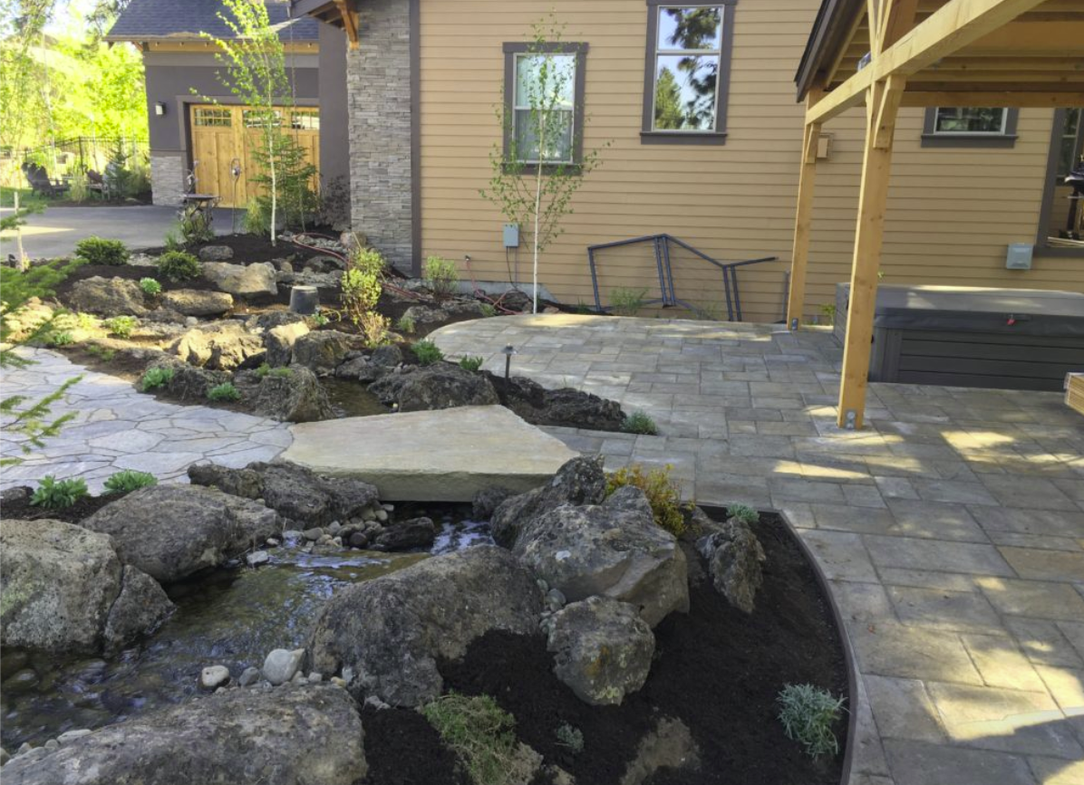 Westside outdoor living space — water feature, paver patio, and pergola overview