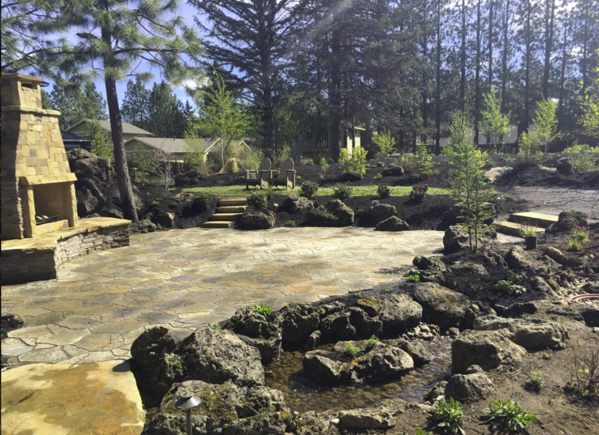 Flagstone patio with outdoor fireplace and fresh planting