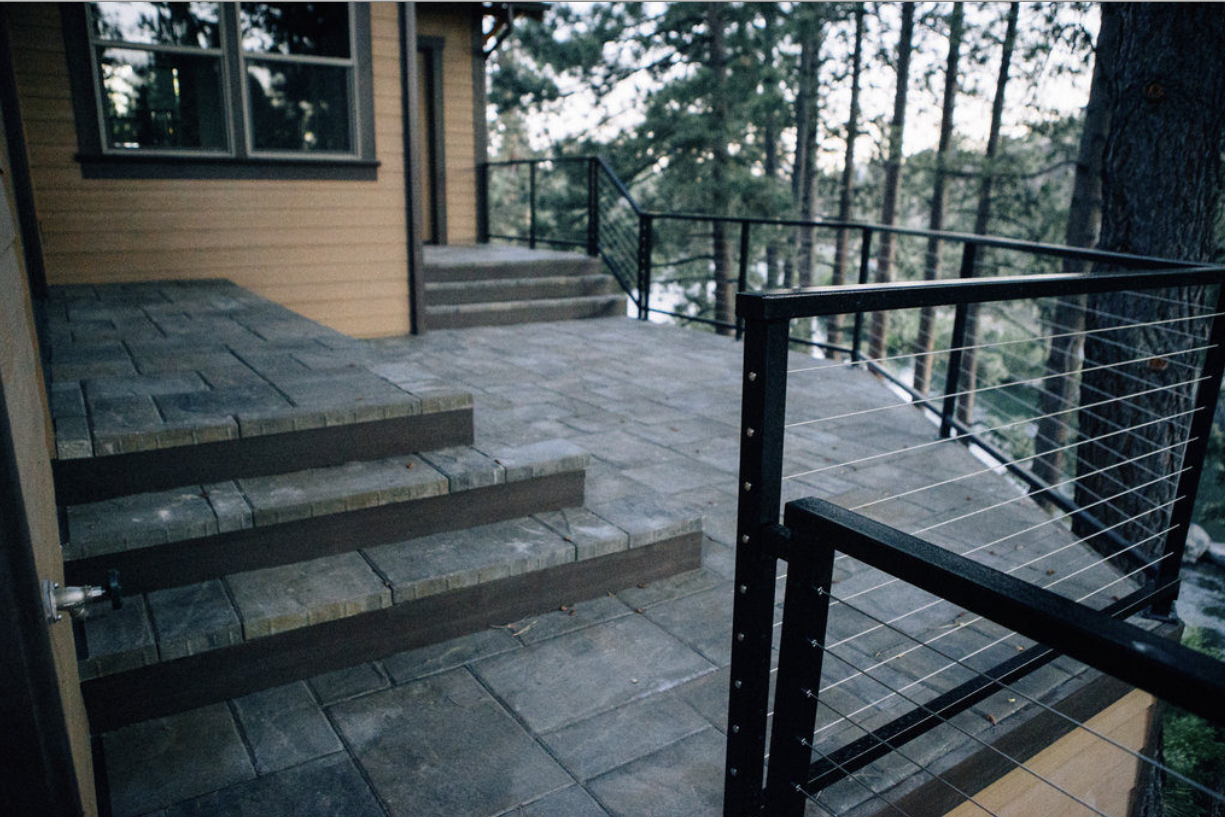 Finished paver steps and cable railing at dusk