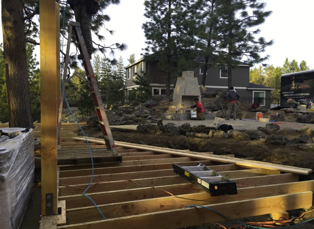 Construction: deck framing, fireplace, and crew working