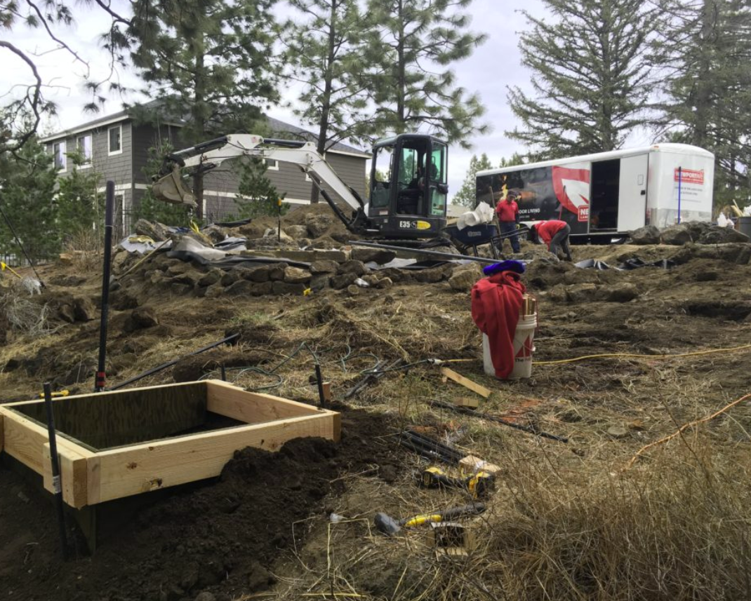 Construction: excavator and crew grading site